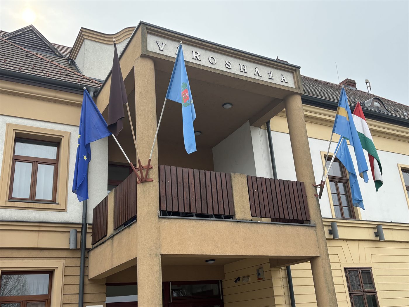 Városháza – EU-, települési és nemzeti zászló egy homlokzaton